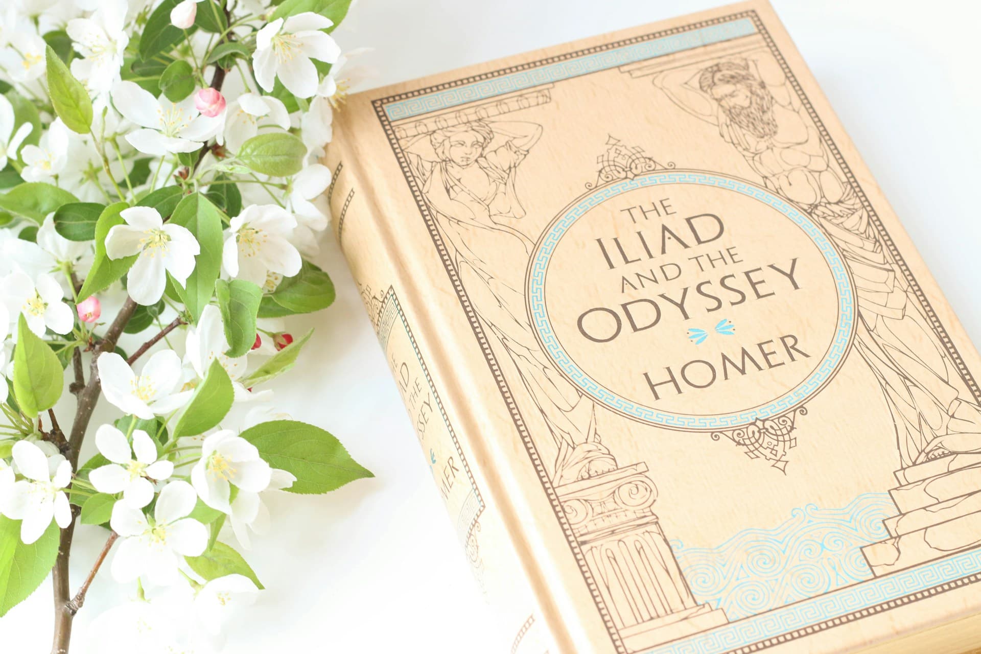 Un livre de l'Iliade et l'Odyssée en anglais avec une branche de lauriers en fleurs