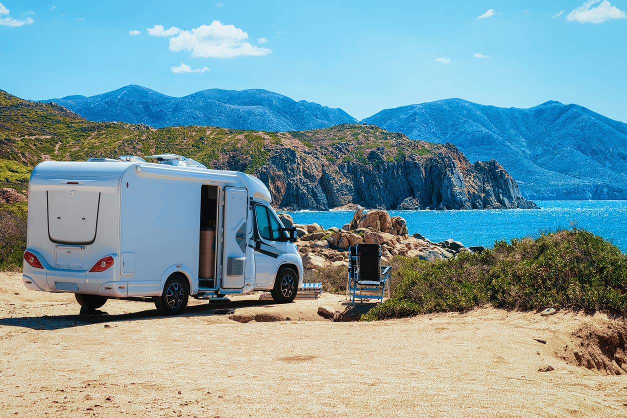 Camping-car avec vue sur la mer et la côte rocheuse.