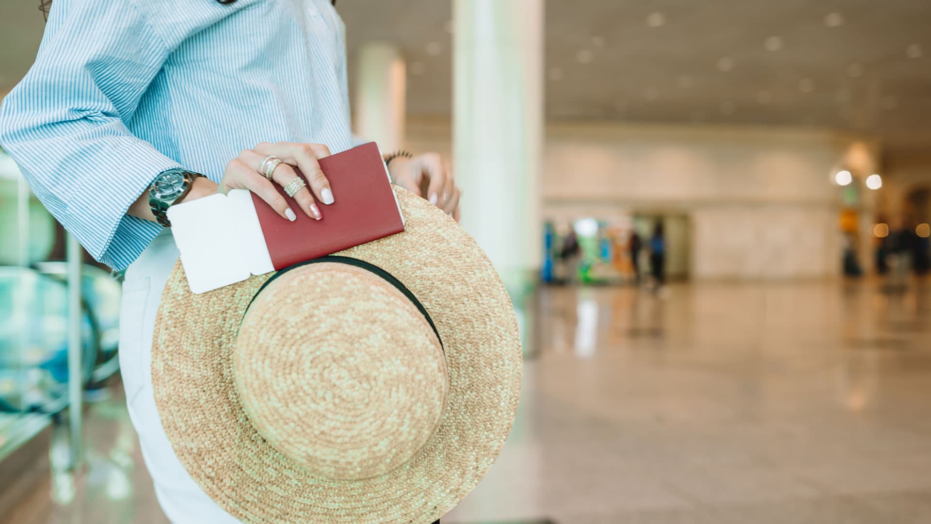 A woman holds her Passport in a bus terminal.