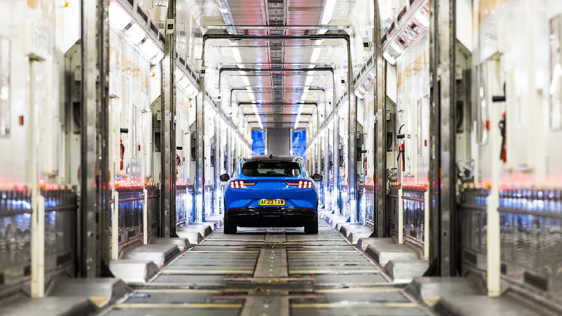 Une voiture bleue traverse le réseau ferroviaire souterrain de LeShuttle.